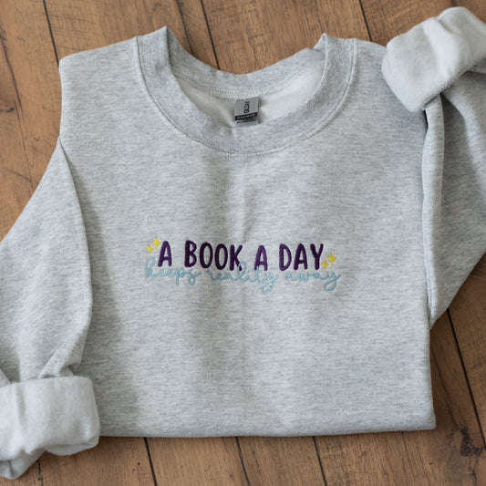 A Book A Day Keeps Reality Away Embroidered Crewneck